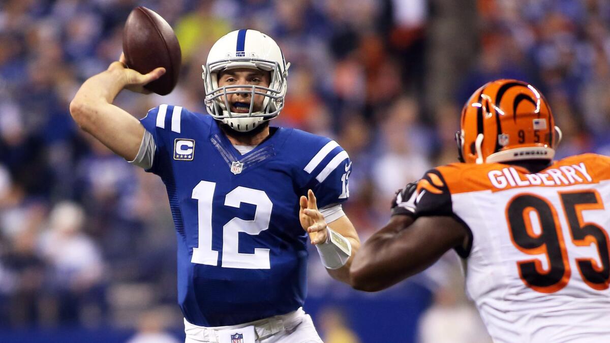 Indianapolis Colts quarterback Andrew Luck, left, throws in front of Cincinnati Bengals defensive end Wallace Gilberry during the Colts' 26-10 AFC wild-card win Sunday.