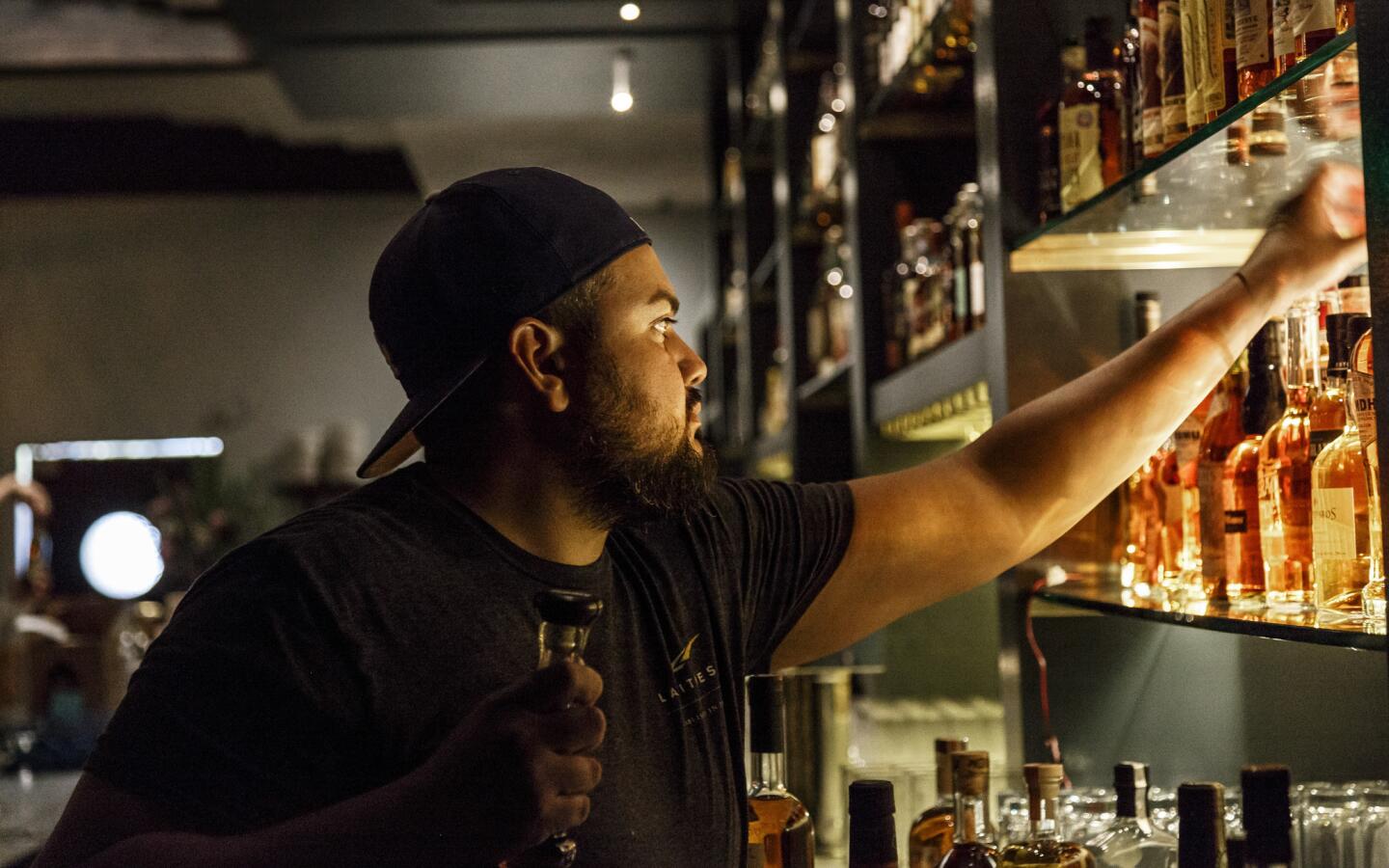 Bar manager Chris Ojeda arranging the shelves at E.R.B., short for Everson Royce Bar, in the downtown Arts District.