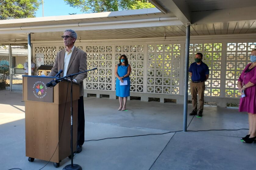San Diego Unified School Board President John Lee Evans, left, speaks at a news conference Tuesday about the timeline for Phase Two of the district's reopening.