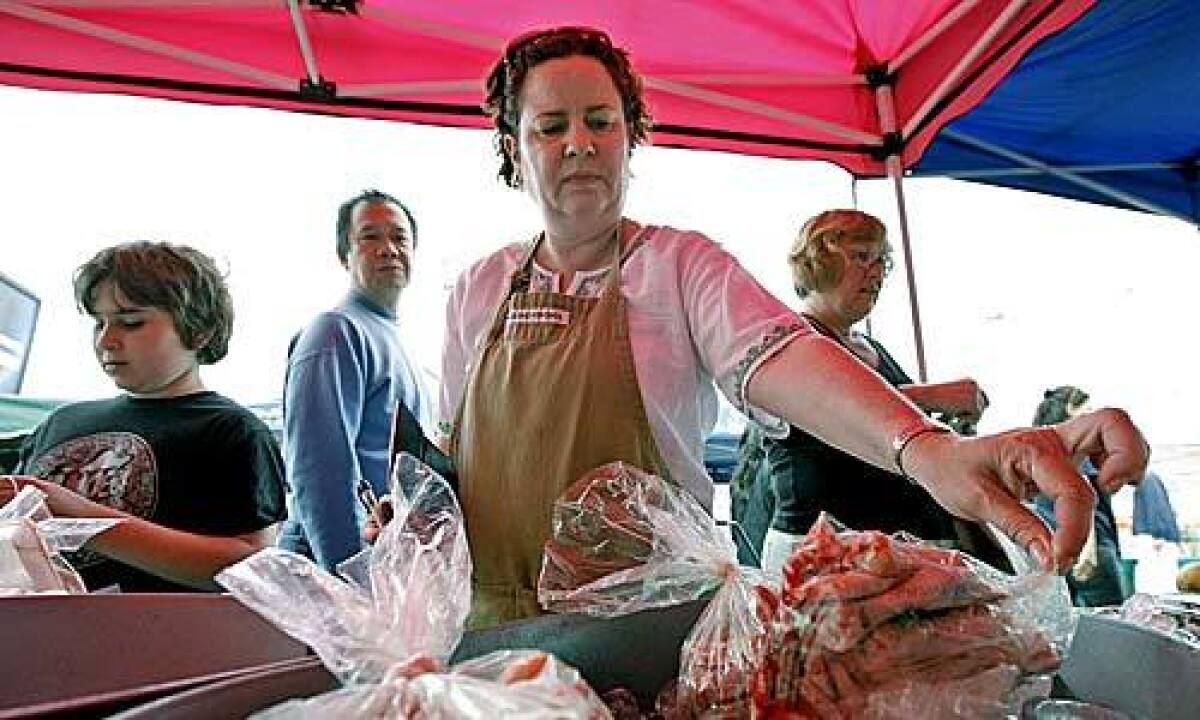 SHOPPING: Eli Selden shops for chicken at the Healthy Family Farms stand at the Hollywood Farmers Market.