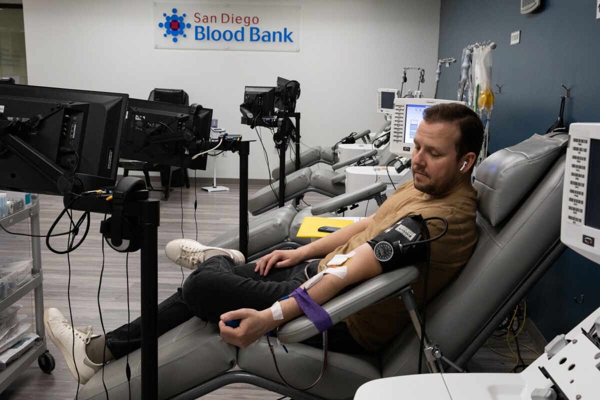 Justin Scholey, 34, donates platelet blood and red blood cells at the San Diego Blood Bank in San Diego on Monday.
