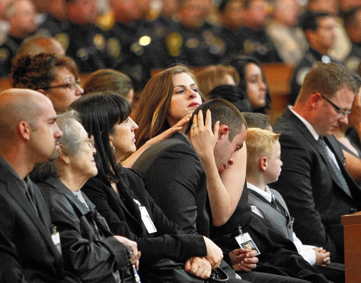 Christina Beal and Jonathan Cortijo, daughter and son of LAPD Officer Christopher A. Cortijo, after speaking at their father’s funeral Mass at the Cathedral of Our Lady of the Angels in downtown Los Angeles.