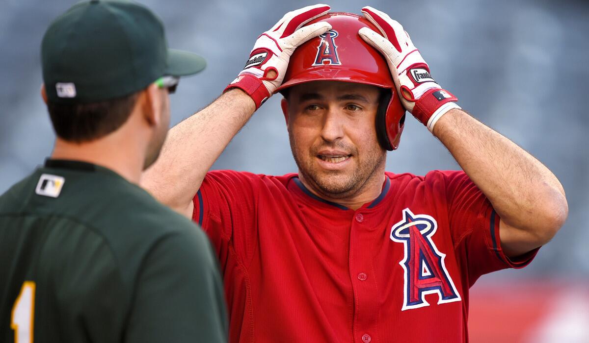 Angels infielder John McDonald chats with A's infielder Nick Punto during batting practice before a game last month.