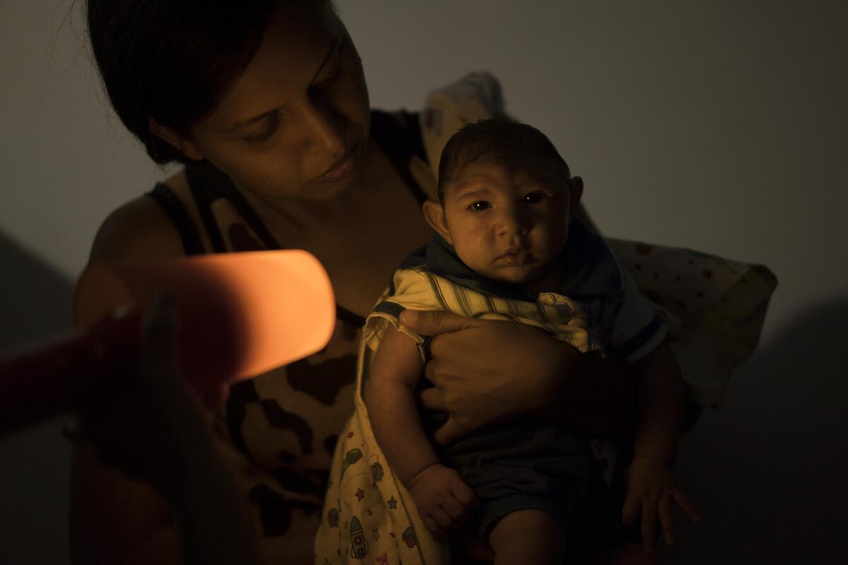Daniele Ferreira dos Santos holds her son Juan Pedro, who was born with microcephaly, during visual stimulation exercises at the Altino Ventura Foundation in Recife, Brazil.
