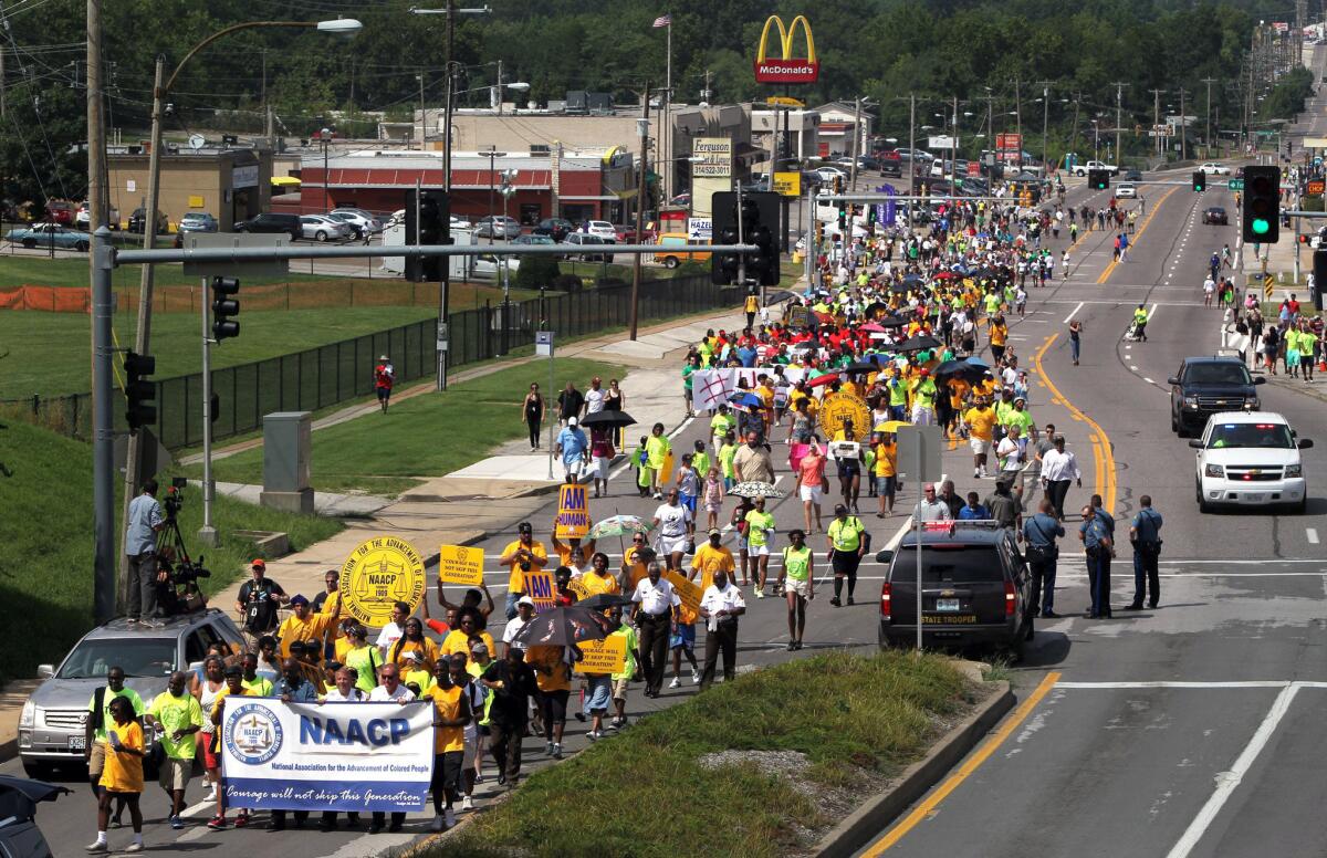 Members of the St. Louis chapters of the NAACP and the National Urban League march on West Florissant Avenue in Ferguson, Mo.