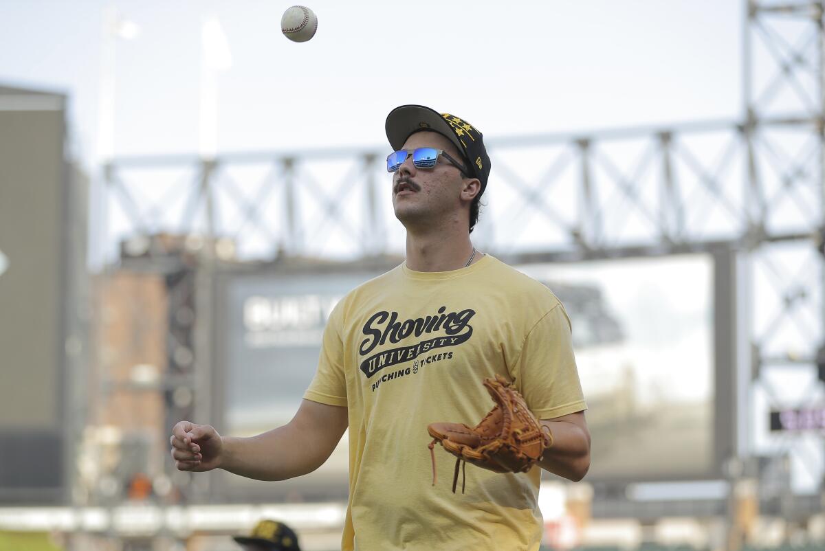 Pittsburgh Pirates pitcher Paul Skenes flips a ball as he walks toward the dugout.