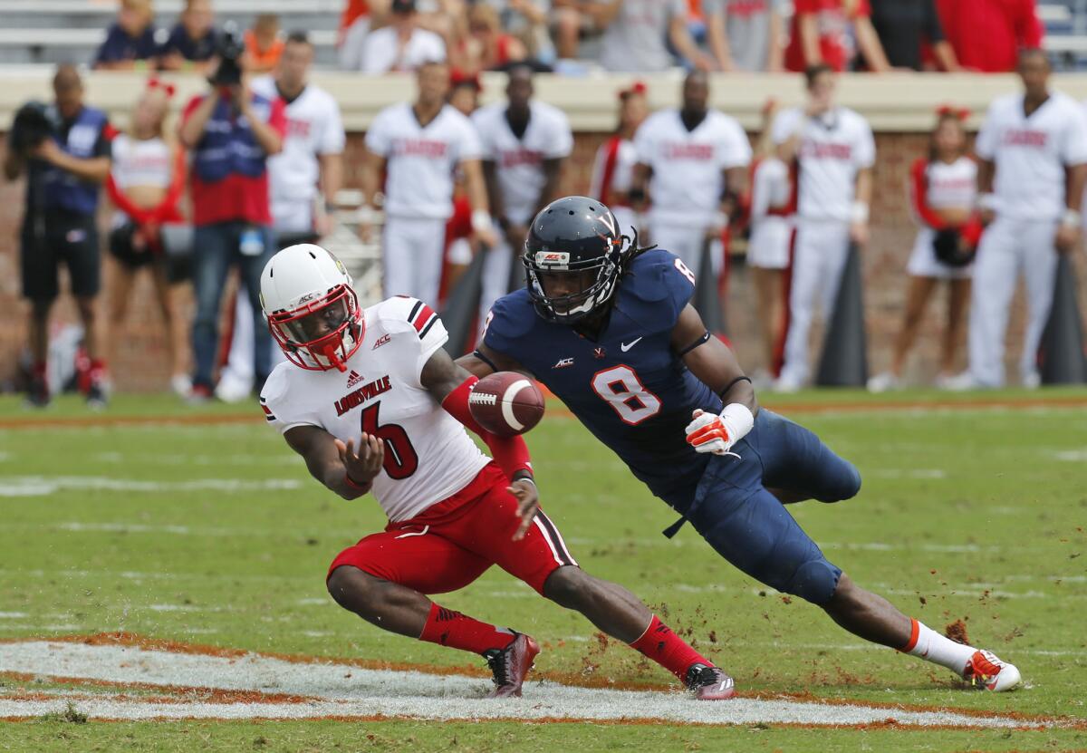 Louisville wide receiver Eli Rogers, left, and Virginia safety Anthony Harris dive for the ball during the Cavaliers' 23-21 upset of the No. 21 Cardinals on Saturday.