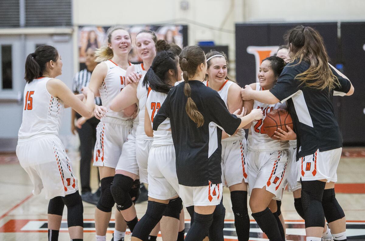 The Huntington Beach girls' basketball team celebrates after beating Aliso Niguel in a first round CIF Southern Section Division 1 playoff game on Feb. 13.