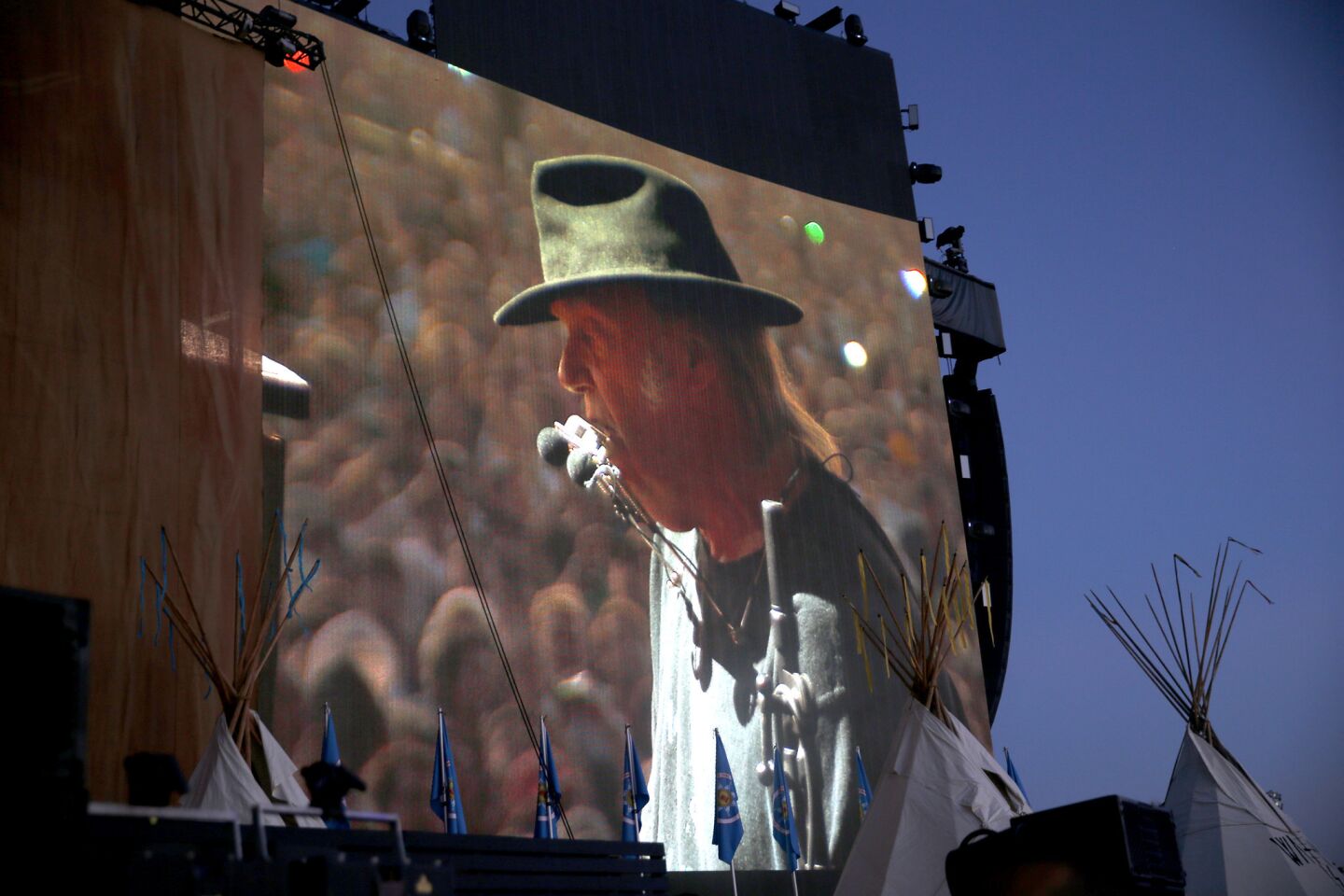 Neil Young is projected on a big screen performing near a teepee on the second day of the three-day Desert Trip.