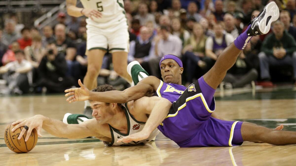 Bucks center Brook Lopez and Lakers guard Rajon Rondo battle for a loose ball during the second half Tuesday.