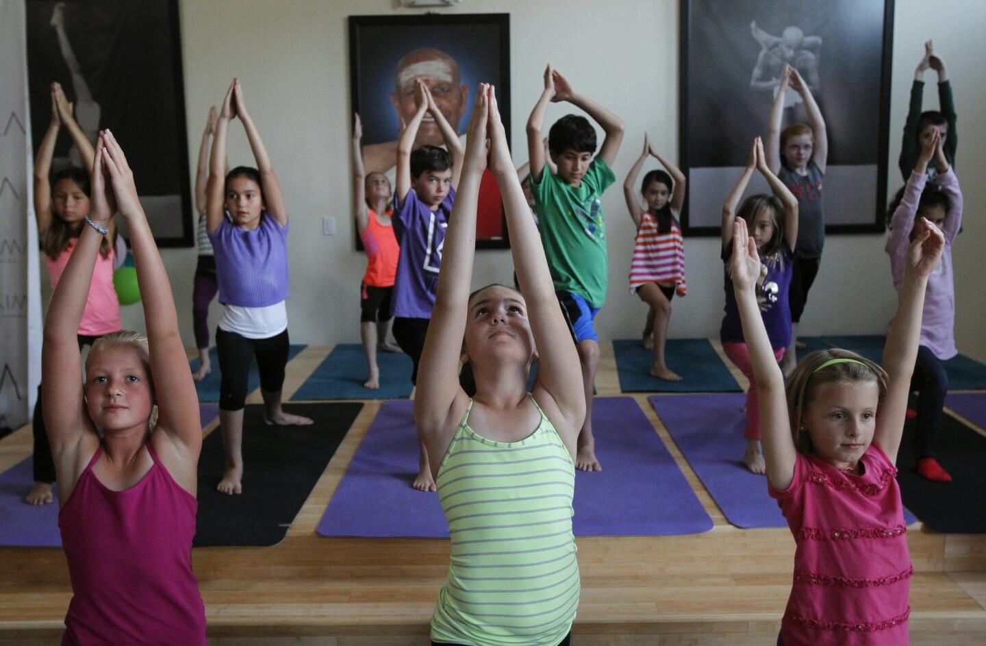 La Costa Heights Elementary School students demonstrate yoga for parents and other adults at the Sonima Foundation yoga studio in Encinitas on Wednesday, April 23, 2014.