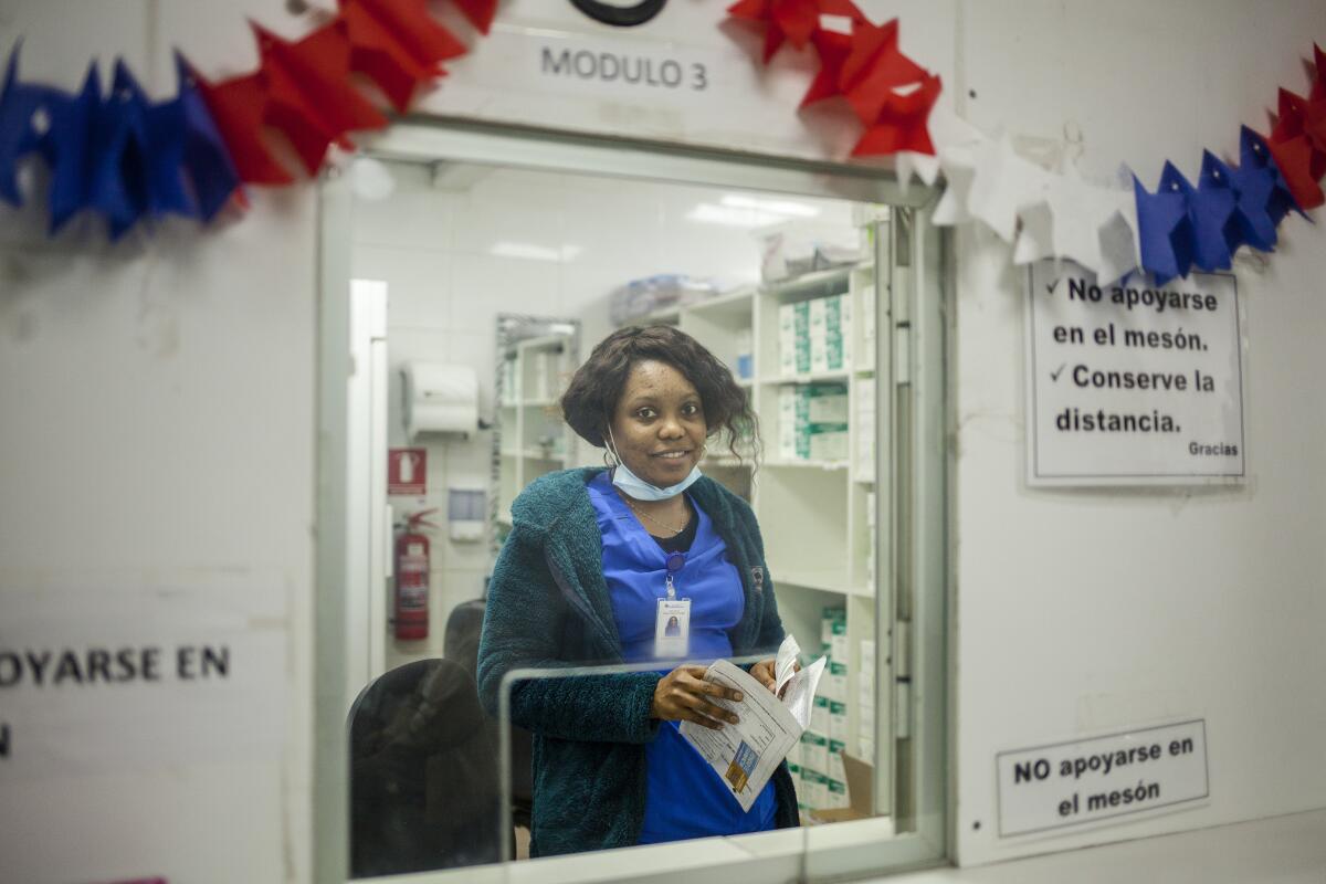 Aline Phanor, 29, a Haitian nursing technician at a clinic pharmacy in northern Santiago.