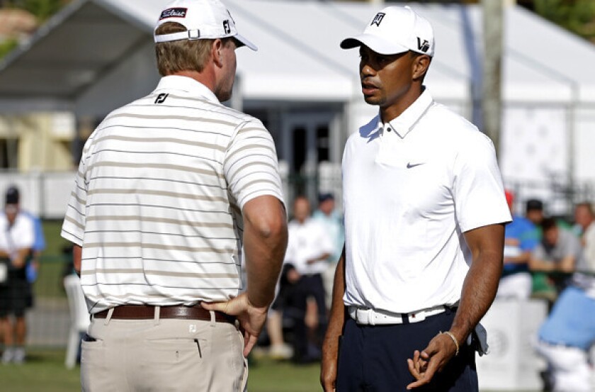 Tiger Woods talks to Steve Stricker on the practice putting green at Doral Golf Resort and Spa on Wednesday.