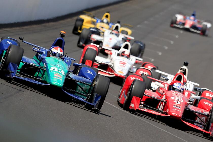 IndyCar driver Charlie Kimball, in No. 83, leads a pack of cars through a turn at the Indianapolis 500 last year.