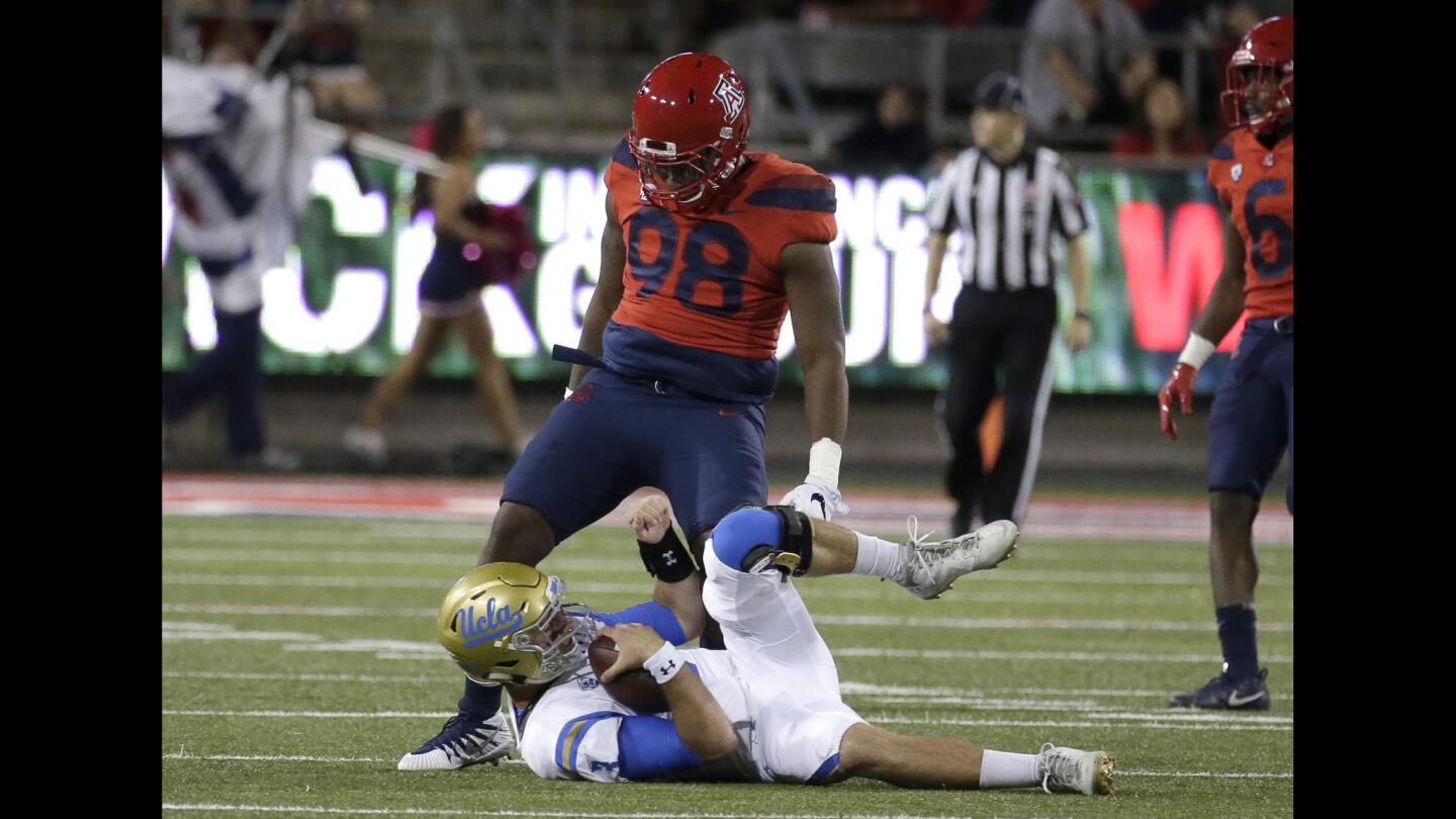 Arizona defensive lineman Larry Tharpe Jr. stands over UCLA's quarterback Josh Rosen in the second half.