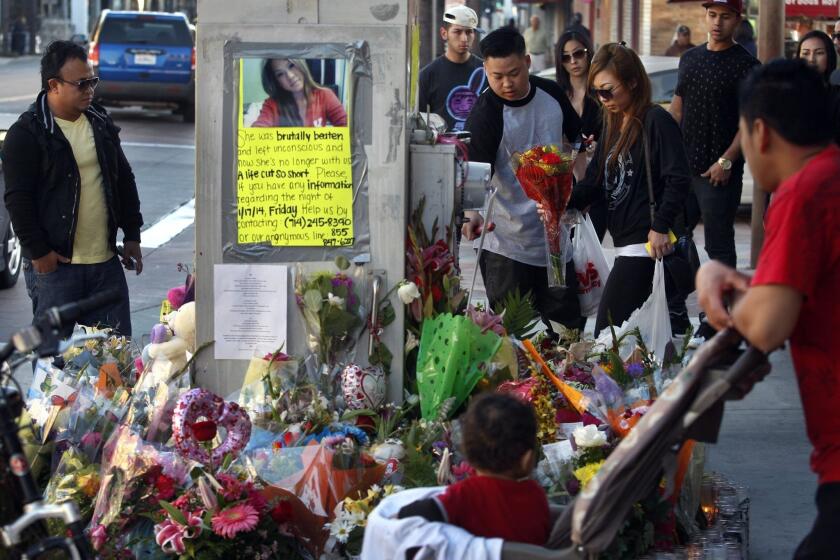 Spectators look over a memorial for Kim Pham, who was beaten to death outside a nightclub in Santa Ana last month.