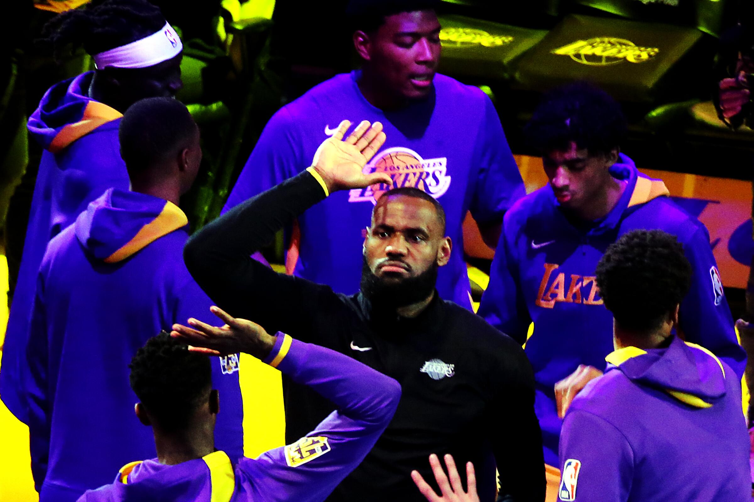 Lakers star LeBron James high-fives teammates during starter introductions before Game 4.