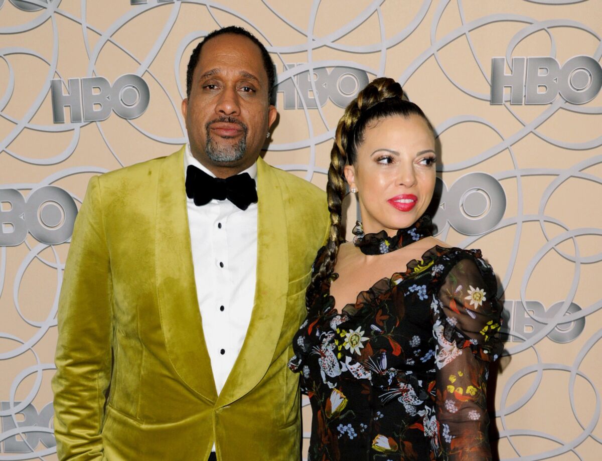 A man in a bright tuxedo jacket and a woman in a colorful dress