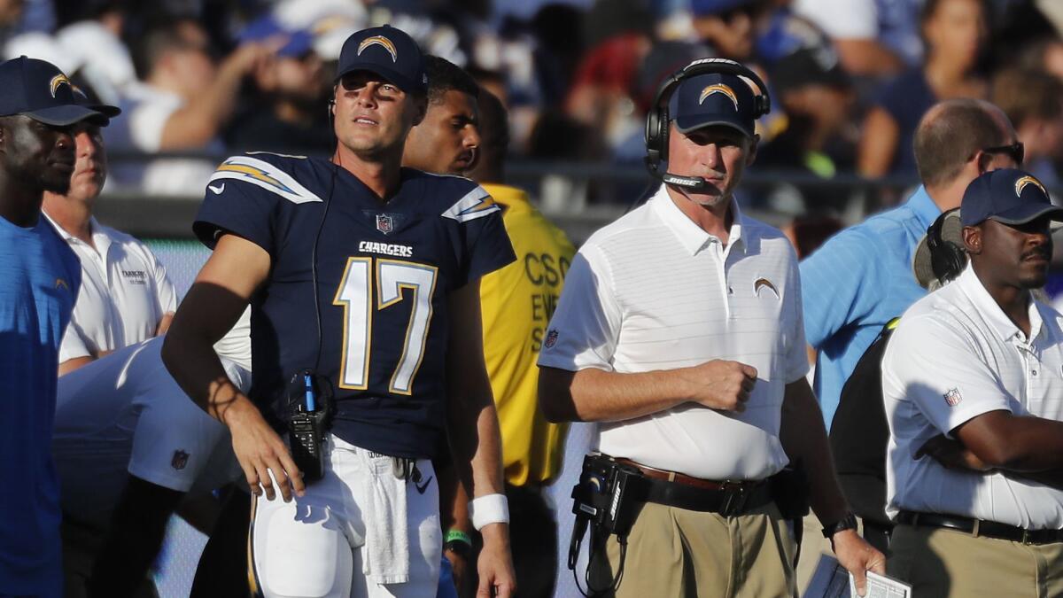 Chargers quarterback Philip Rivers, left, and offensive coordinator Ken Whisenhunt, right, watch from sideline.