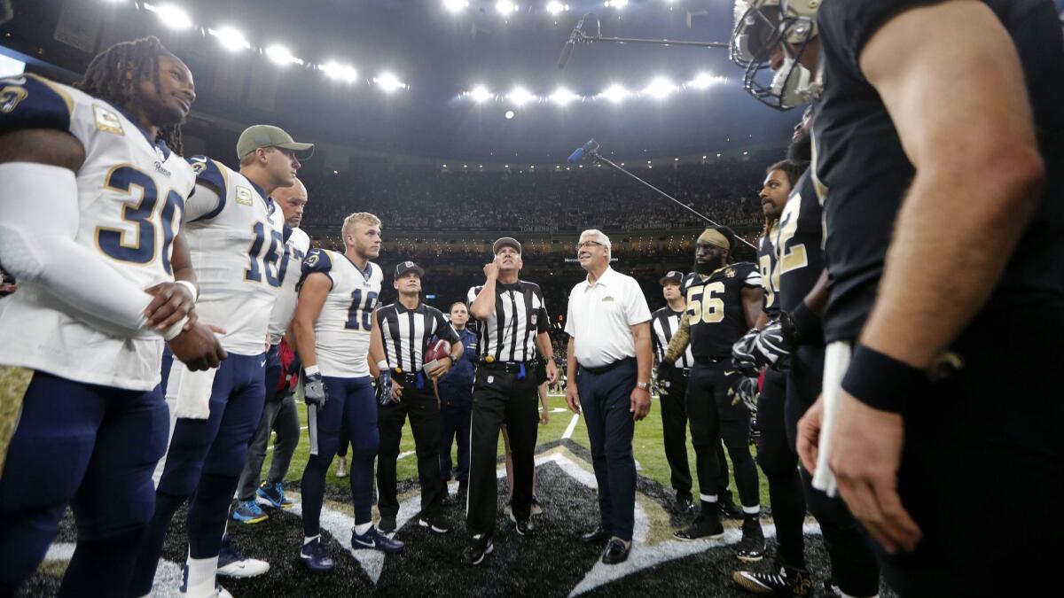 A referee performs the coin toss before the game between the Rams and the New Orleans Saints on Nov. 4 at the Mercedes-Benz Superdome.