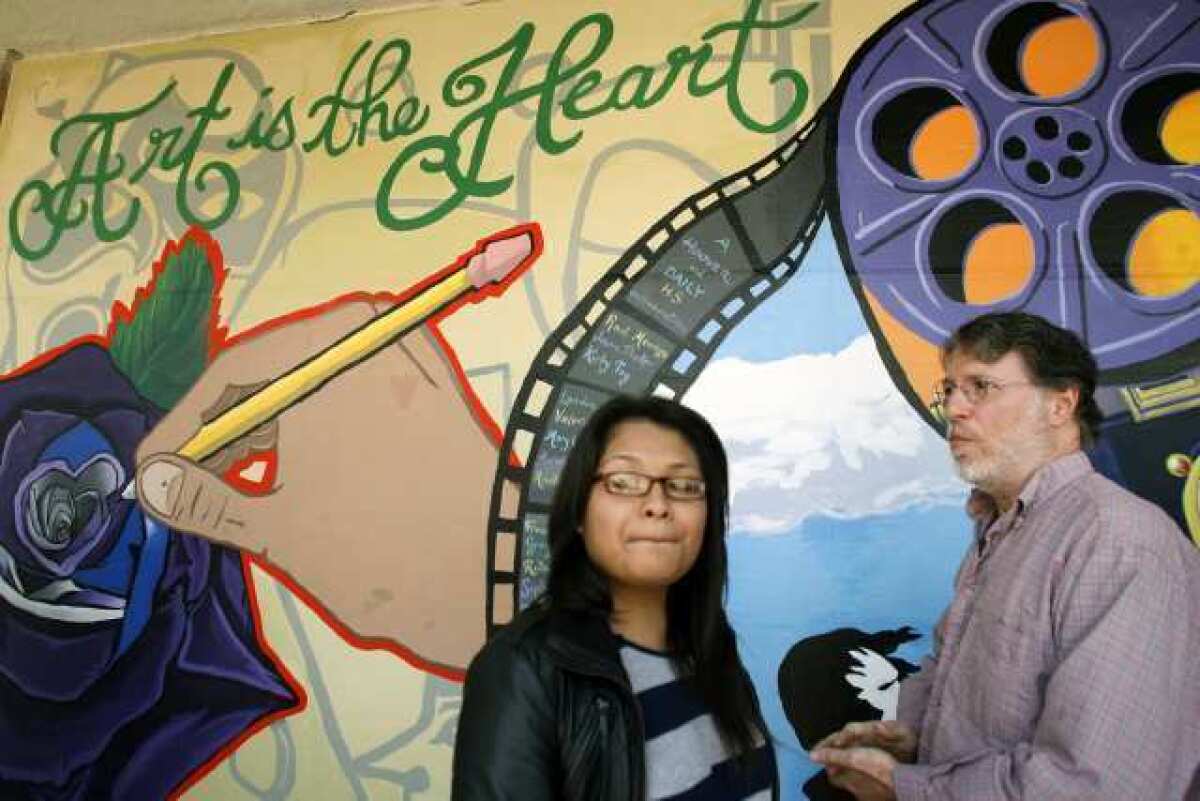 Daily High School student Jennifer Aviles, 18, left, and professional muralist Roger Dolin take a look at a mural during a ceremony, which took place at Hoover High School in Glendale.
