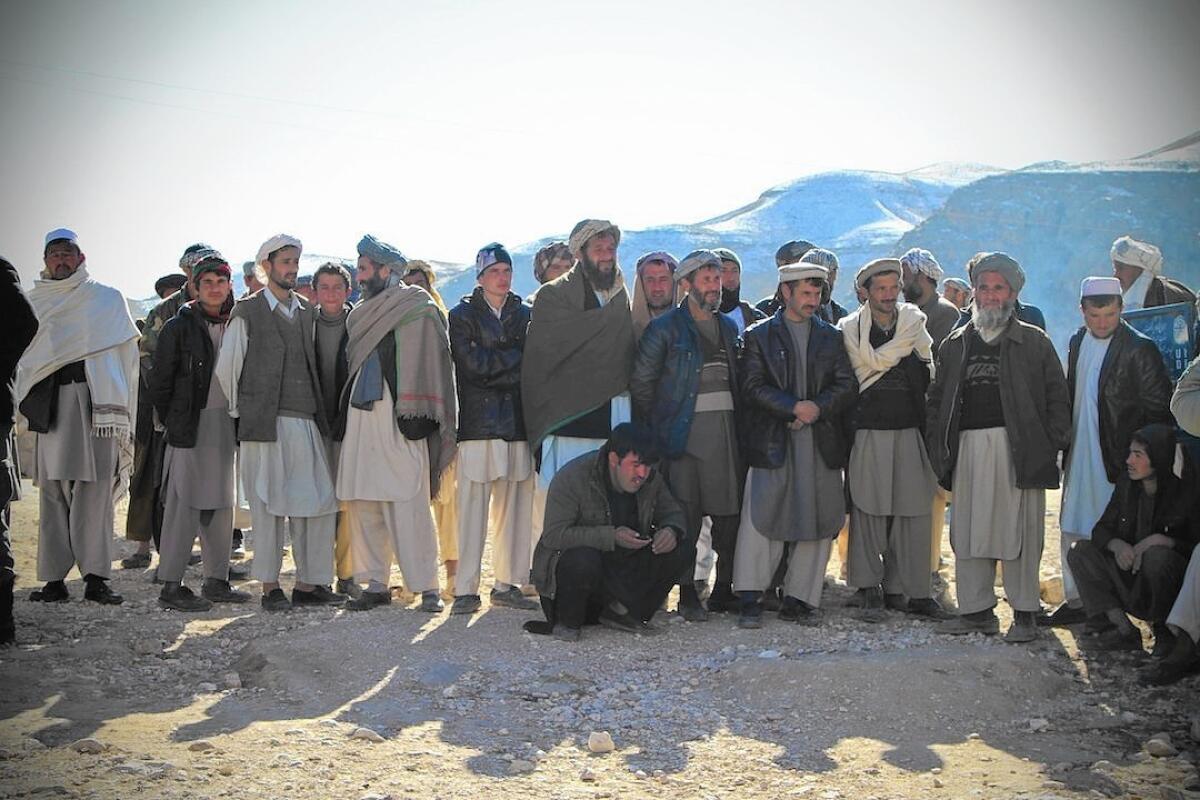 Afghan men in Samangan province wait for the distribution of aid packages, an effort led by First Lady Rula Ghani.