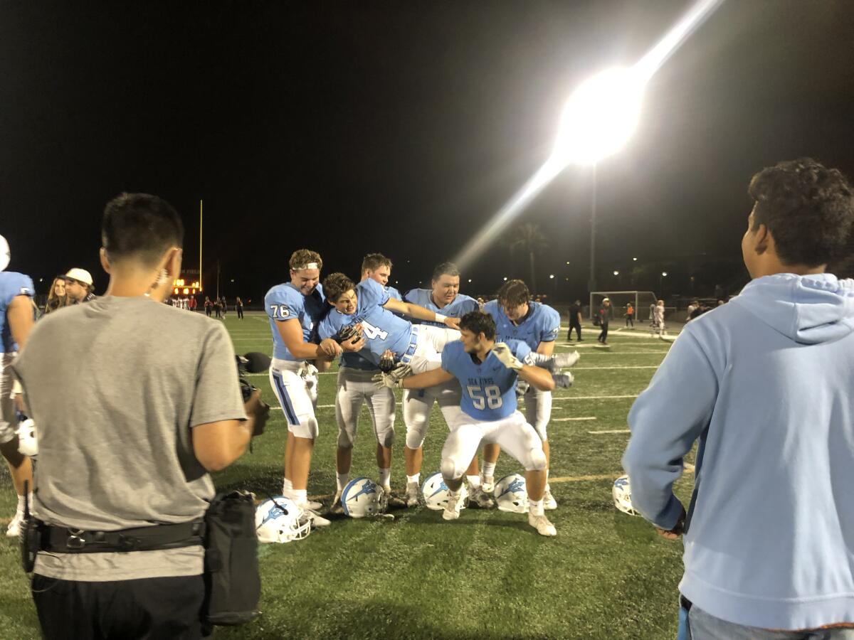 Quarterback Ethan Garbers of Corona del Mar poses with his offensive line after 42-21 win over San Clemente.