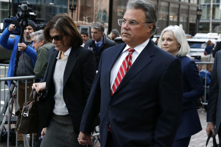BOSTON, MA - APRIL 3: Manuel, right, and Elizabeth Henriquez leave the John Joseph Moakley United States Courthouse in Boston on April 3, 2019. 13 parents were scheduled to appear in federal court in Boston Wednesday for the first time since they were charged last month in a massive college admissions cheating scandal. They were among 50 people - including coaches, powerful financiers, and entrepreneurs - charged in a brazen plot in which wealthy parents allegedly schemed to bribe sports coaches at top colleges to admit their children. Many of the parents allegedly paid to have someone else take the SAT or ACT exams for their children or correct their answers, guaranteeing them high scores. (Photo by Jessica Rinaldi/The Boston Globe via Getty Images)