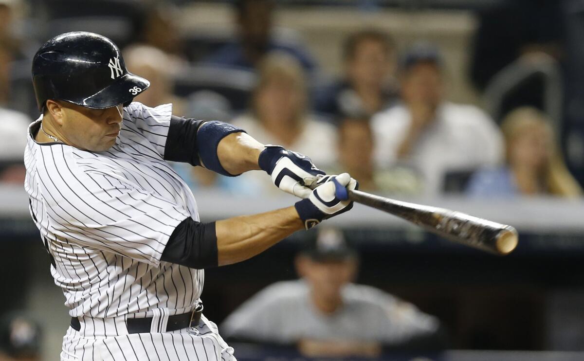 Yankees outfielder Carlos Beltran hits a two-run home run against the Marlins during a game on June 18 at Yankee Stadium.