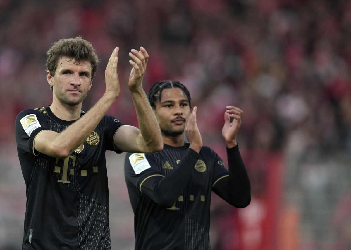Bayern's Thomas Mueller, left, and Serge Gnabry applaud at the end of the German Bundesliga soccer match between 1. FC Union Berlin and FC Bayern Munich in Berlin, Germany, Saturday, Oct. 30, 2021. (AP Photo/Michael Sohn)