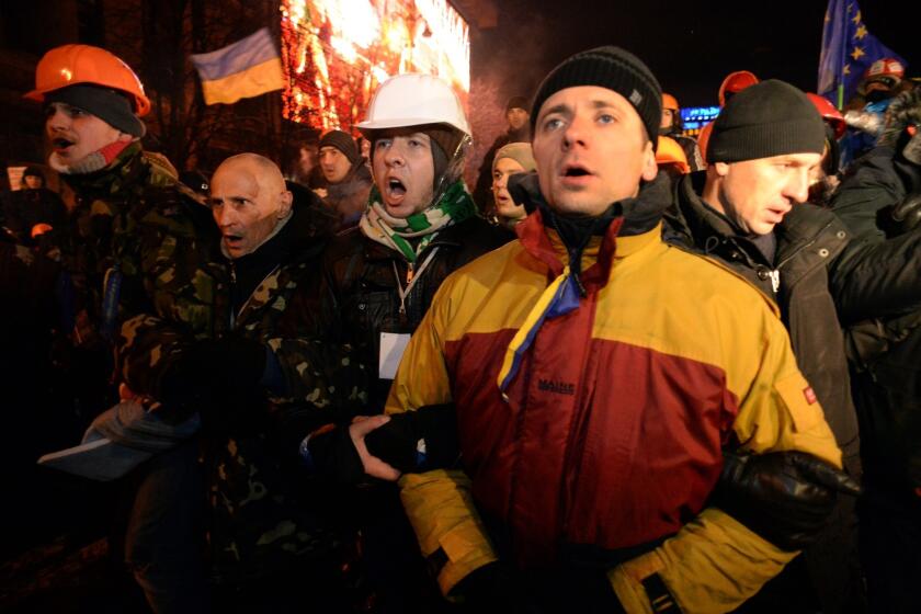 Protesters defend their barricades in front of riot policemen on Independence Square in Kiev.