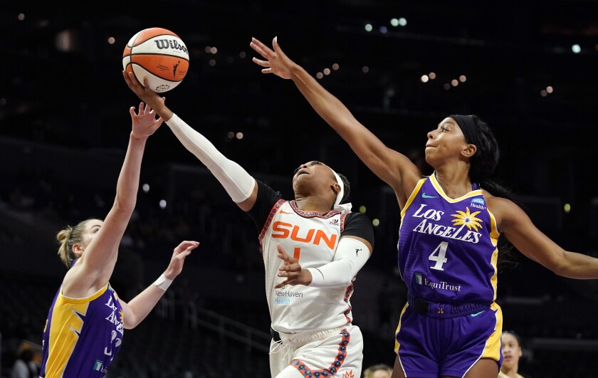 Connecticut Sun guard Odyssey Sims shoots as Sparks forward Katie Lou Samuelson and guard Lexie Brown defend.