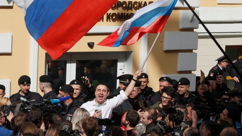 Russian opposition candidate Ivan Zhdanov waves a flag at a Moscow rally Sunday in support of opposition candidates removed from a local election.