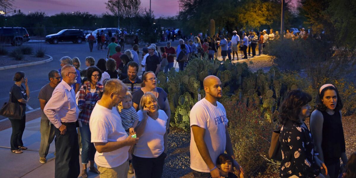 People wait in line to vote on March 22 in Chandler, Ariz. Five polling places in the Phoenix area reportedly still had voters in line after midnight during the state's recent presidential primary.