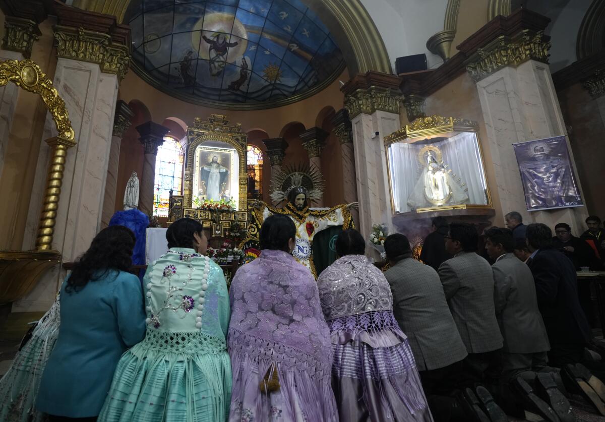 Devotos rezan después de vestir la estatua de Jesús del Gran Poder en la iglesia Jesús del Gran Poder 