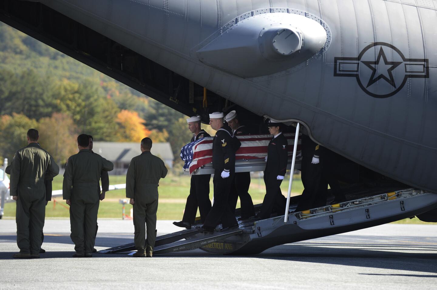 The remains of Navy Fireman 3rd Class Edwin Hopkins is carried off a C-130 military plane after being flown around the area in honor before landing at Dillant-Hopkins Airport in Keene, N.H. Hopkins died during the Japanese attack on Pearl Harbor on Dec. 7, 1941.
