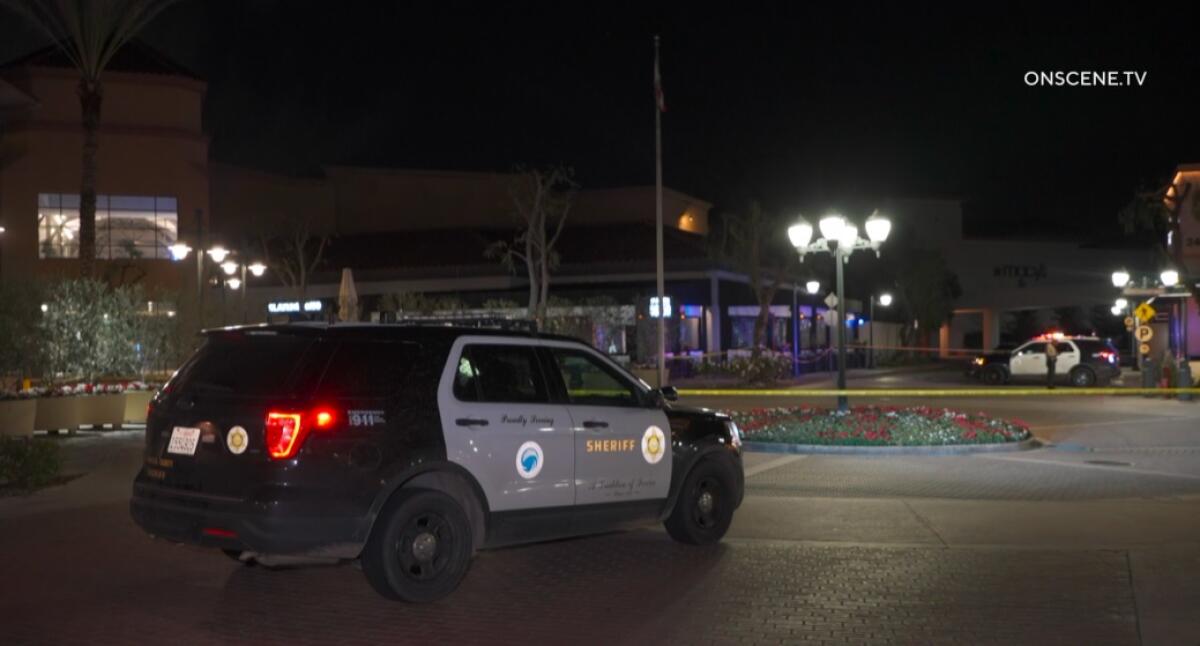 A sheriff's SUV outside a shopping center with yellow crime scene tape