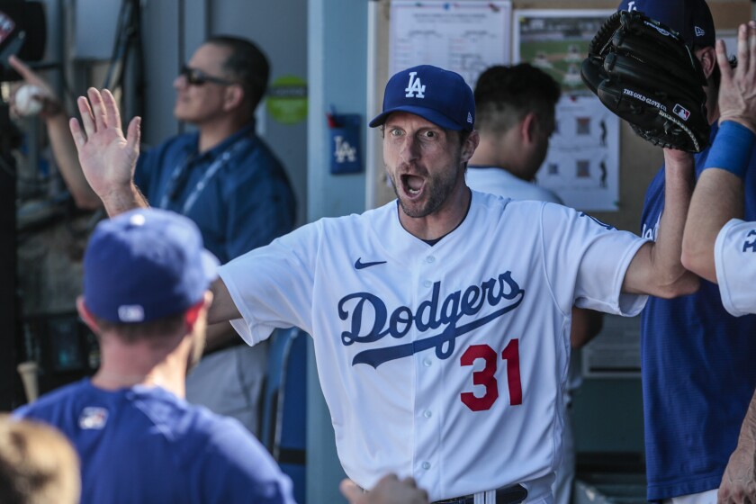 Dodgers starting pitcher Max Scherzer gestures in the dugout during the eighth inning.