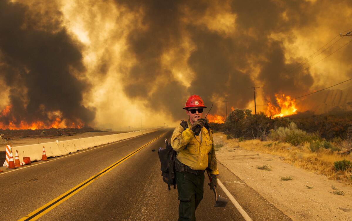 A firefighter radios that the Blue Cut fire is burning on both sides of Highway 138.