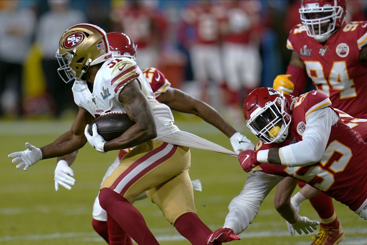 FILE - In this Feb. 2, 2020, file photo, Kansas City Chiefs defensive end Frank Clark, right, tries to tackle San Francisco 49ers running back Raheem Mostert during the first half of the NFL Super Bowl 54 football game in Miami Gardens, Fla. The 49ers open their season against the Arizona Cardinals this week. (AP Photo/David J. Phillip, File)
