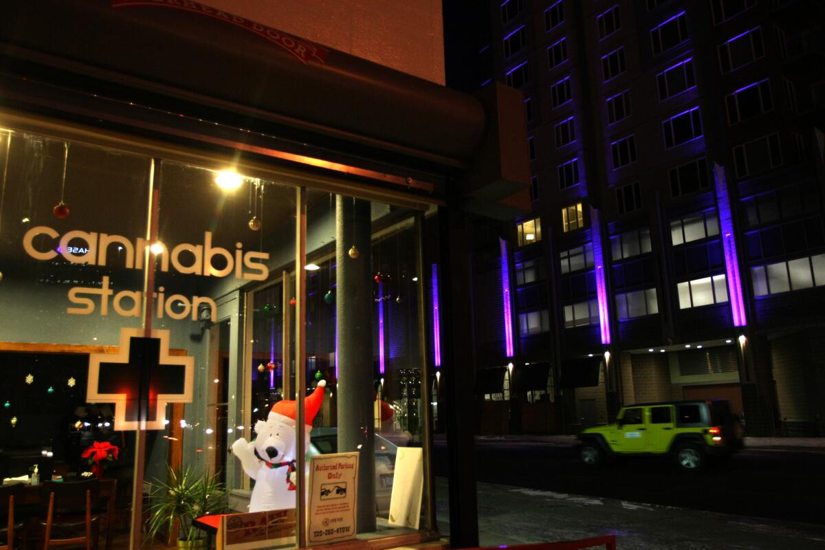 A car passes by the Cannabis Station, a marijuana dispensary in downtown Denver.