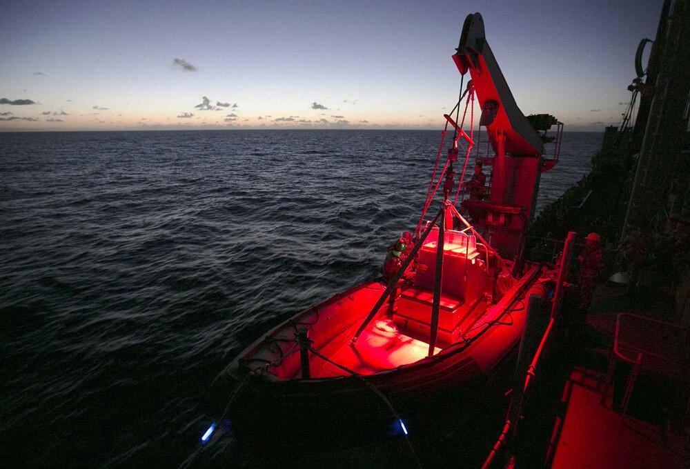 A handout photo taken April 4, 2014, and released April 7 shows the HMAS Success readying a Rigid Hull Inflatable Boat near dusk after a reported sighting of potential debris in the vicinity during the search for missing Malaysia Airlines Flight MH370 in the southern Indian Ocean.
