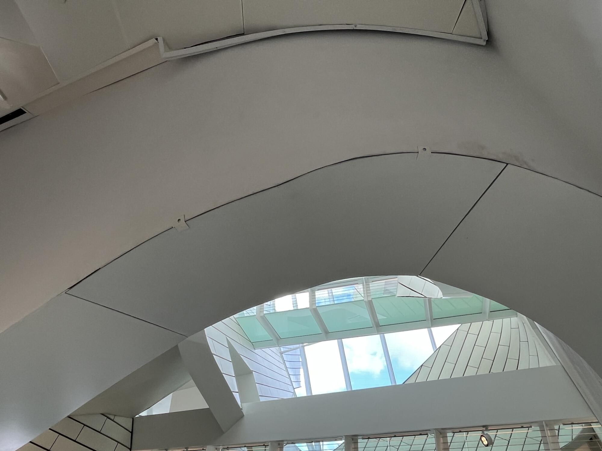 A view of a bend in a ceiling arch reveals poorly aligned boards clamped together in lieu of steel panels.