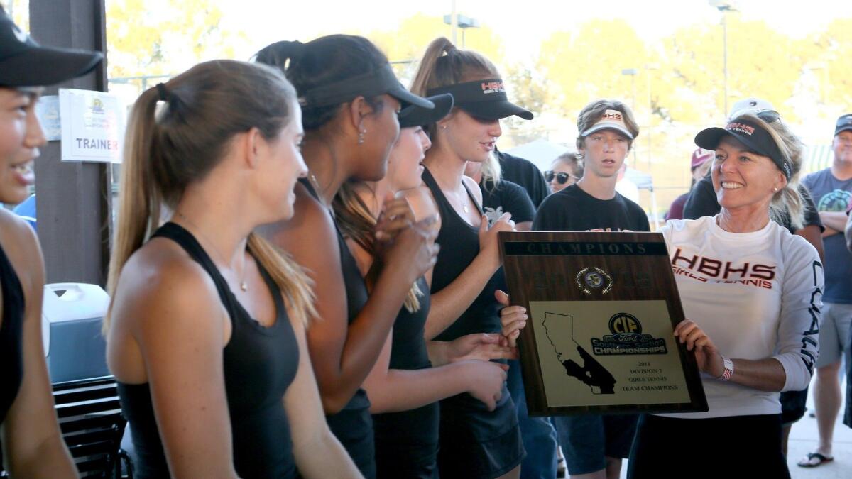 Huntington Beach High coach Suzanne DeVries holds the CIF Southern Section Division 3 championship plaque her team won at the Claremont Club on Nov. 9, 2018.
