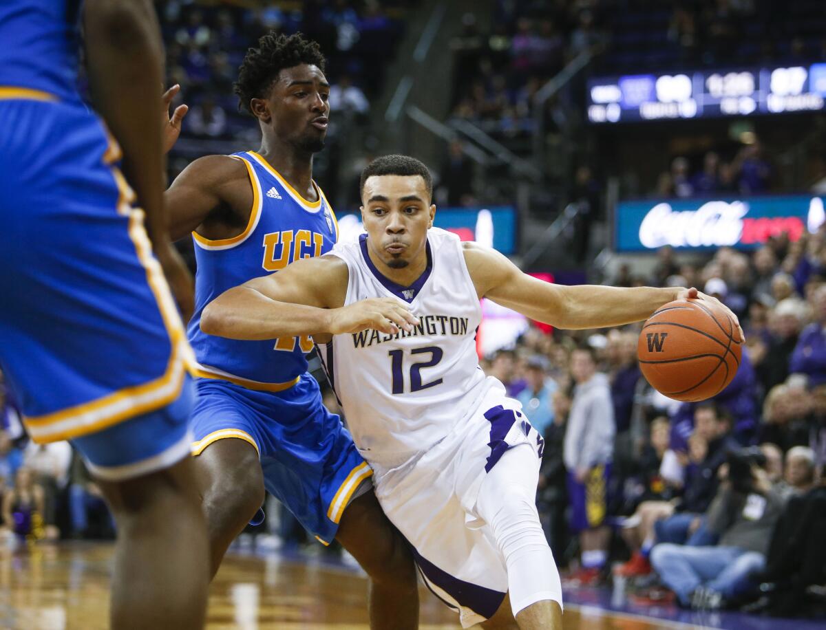 Washington guard Andrew Andrews (12) dribbles past UCLA guard Isaac Hamilton (10) during the second overtime.