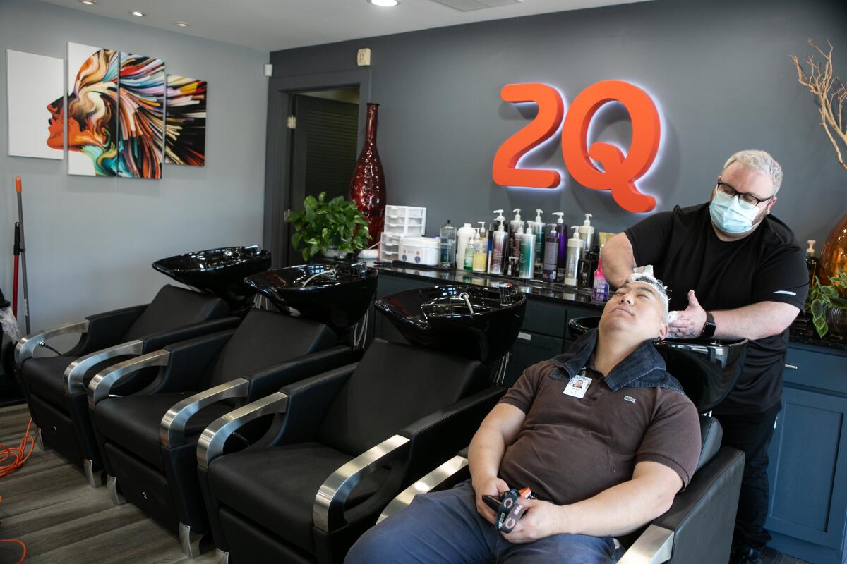 Harris Little washes Matt Kim's hair at 2Qute Hair Salon in Atlanta on April 27.