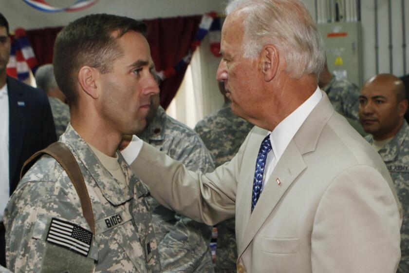 Vice President Joe Biden, right, talks with his son, U.S. Army Capt. Beau Biden, at Camp Victory on the outskirts of Baghdad, Iraq in 2009.