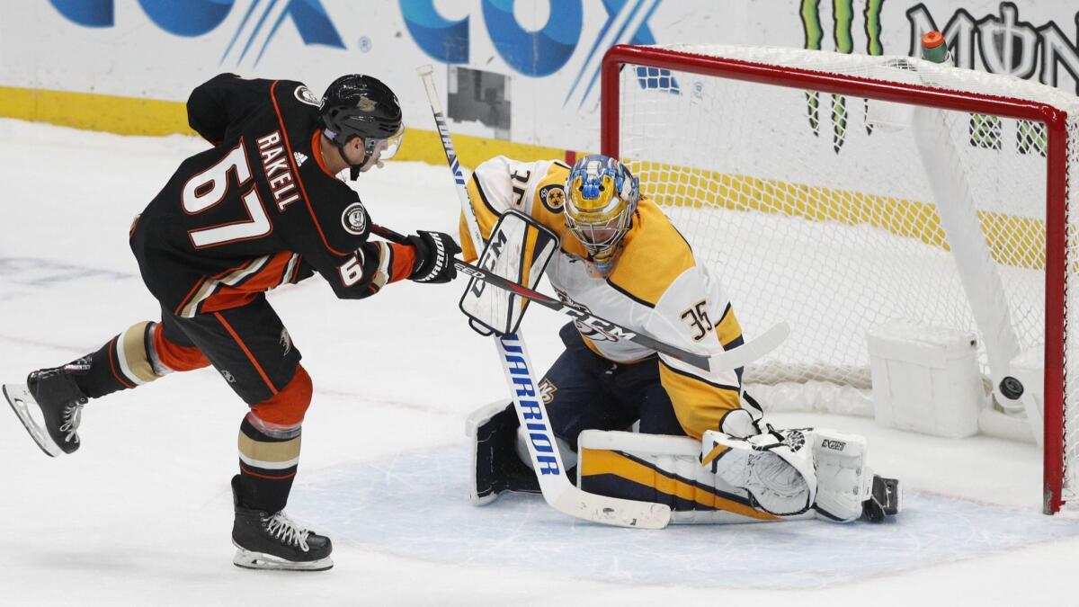 Ducks' Rickard Rakell, left, scores against Nashville goaltender Pekka Rinne.