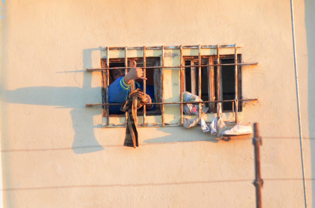 Un preso grita y gesticula desde una ventana enrejada de la prisión de Topo Chico.