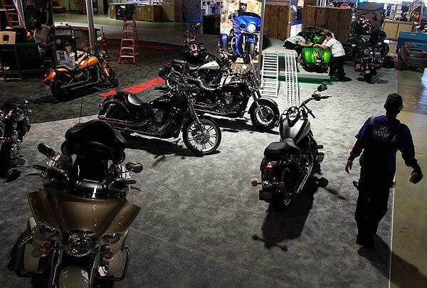 Workers set up the Kawasaki display at the International Motorcycle Show at the Long Beach Convention Center.